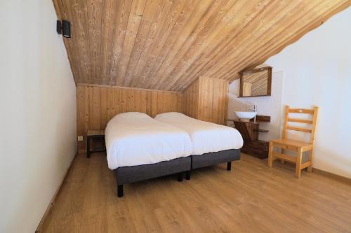 a bedroom with a bed with a wooden ceiling at Résidence Aiguille Lodge in Les Deux Alpes