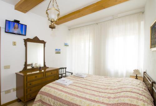 1 dormitorio con cama, espejo y tocador en Cheap Apartment in The Old Village, en Colle Val D'Elsa