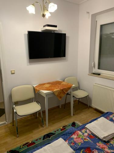 a room with a table and two chairs and a television at Haus Kristina in Csopak