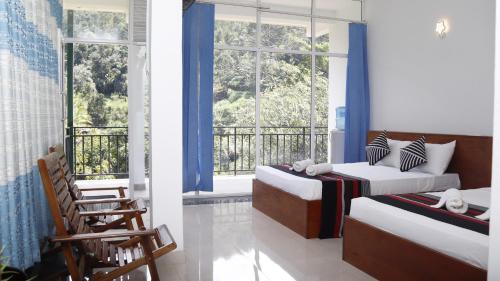 a bedroom with two beds and a balcony at Boo Kirinda Holiday Resort in Badulla