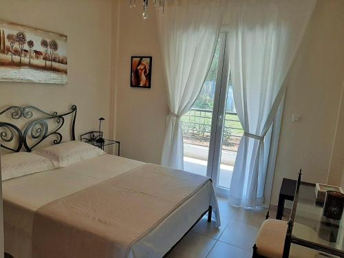 a bedroom with a bed and a large window at Bel Air in Skala Potamias