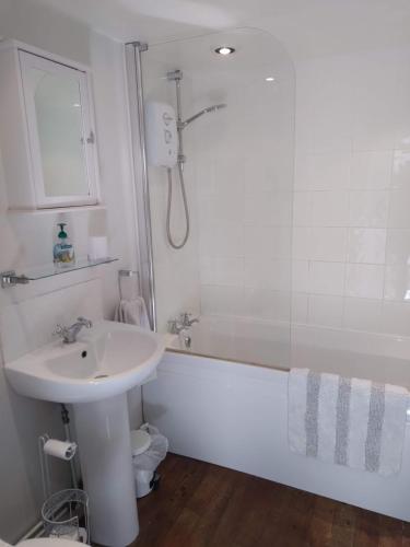 a bathroom with a sink and a bath tub with a sink at Brick Kiln Apartment in Campsea Ashe