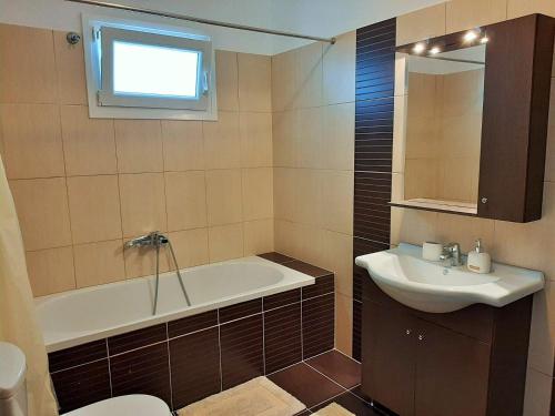 a bathroom with a bath tub and a sink at Bel Air in Skala Potamias