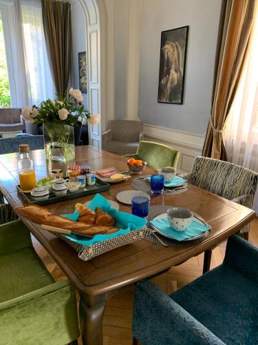 een houten tafel met eten in de woonkamer bij Maison Longuevie in Amiens