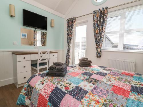a bedroom with a bed with a quilt on it at Shore Thing 279 in Bridlington