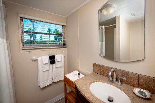 a bathroom with a sink and a mirror at Cedar Cove Resort & Cottages in Holmes Beach