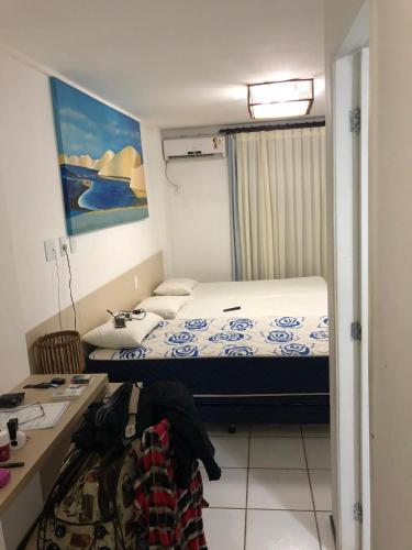 a small bedroom with a bed and a desk at Aptos Gran Lencois Flat Res. in Barreirinhas