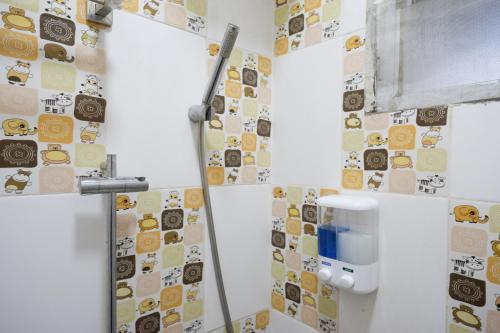 a bathroom with a bunch of stickers on the wall at RedDoorz Syariah at Omah Sawah in Balong