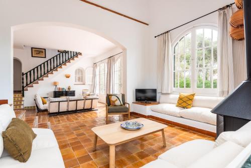 a living room with white furniture and a staircase at Villa Los Dragones in Son Parc