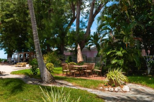 a patio with a table and chairs and trees at Cedar Cove Resort & Cottages in Holmes Beach