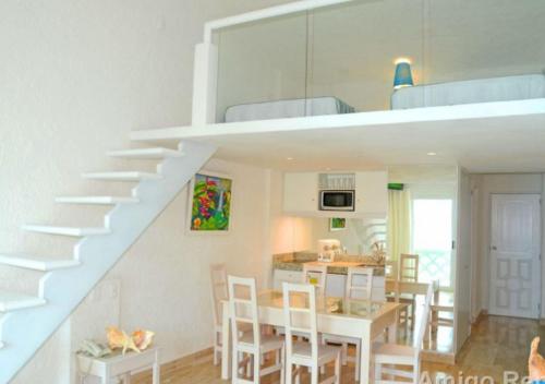 una cocina y comedor con una escalera en una casa en Apartamento Front en la Playa Cancun Mexico, en Cancún