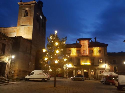 a christmas tree in front of a building at night at Hotel Virginia R.H. in Vinuesa