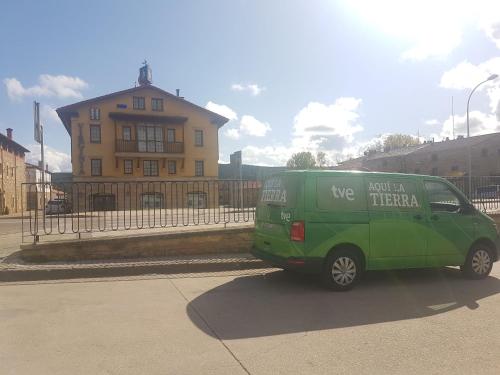 a green van is parked in a parking lot at Hotel Virginia R.H. in Vinuesa