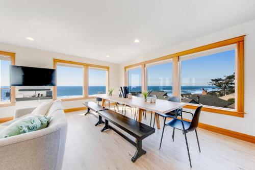 a living room with a dining room table with a view of the ocean at Blue Wave Heights in Lincoln City