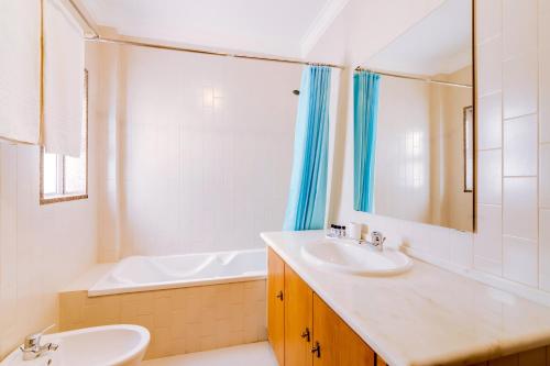 クアルテイラにあるAL- Apartamentos Novos Vista Marのバスルーム(シンク、バスタブ、鏡付)