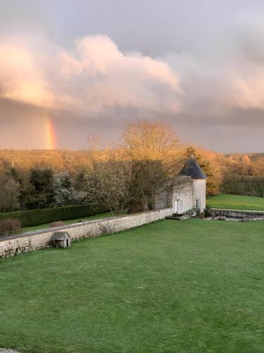 an old building with a rainbow in the background at Manoir de Conjon in Crouay