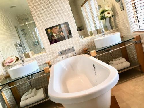 a bathroom with a large tub and two sinks at Number One St Lukes in Blackpool