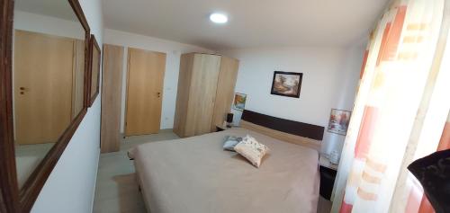 a small bedroom with a bed and a window at Apartman Šarm Srebrno jezero in Veliko Gradište