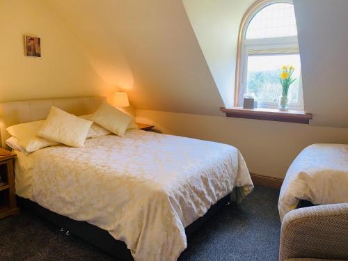 a bedroom with a bed and a window at Lakeview Guest House in Stranraer