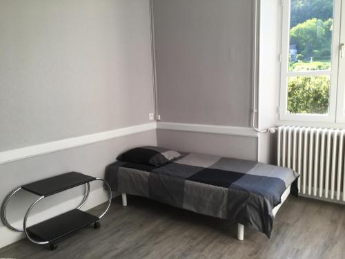 ein kleines Schlafzimmer mit einem Bett und einem Stuhl in der Unterkunft Appartement Alloix in Sainte-Marie-dʼAlloix