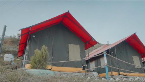 a large building with a red and black roof at Camp O Royale in Dhanaulti