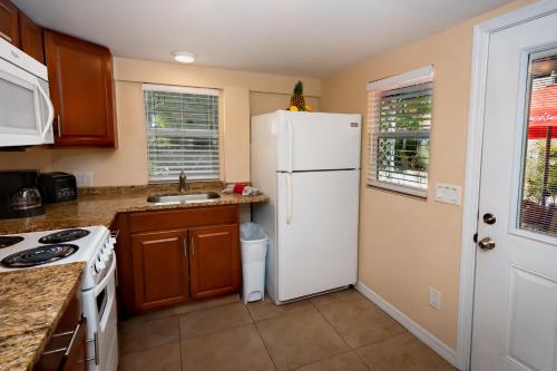 a kitchen with a white refrigerator and a sink at Cedar Cove Resort & Cottages in Holmes Beach