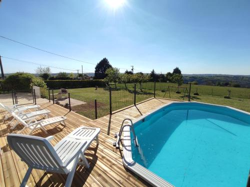 - une piscine sur une terrasse en bois avec 2 chaises longues dans l'établissement Le Gîte du Moulin à Vent, à Plazac