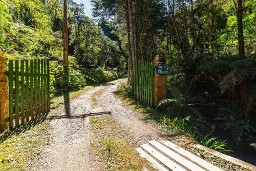 a dirt road with a gate and a sign on it at Vale do Lajeado - Mountain chalets in Campos do Jordão