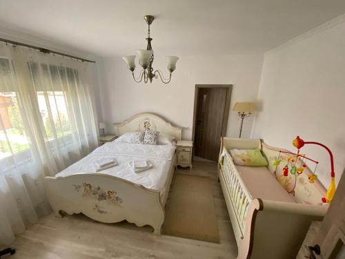 1 dormitorio con cama, sofá y lámpara de araña en Sia & Sophie 's House en Sîntandrei