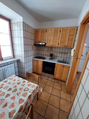 a kitchen with wooden cabinets and a table and a table and a table at Appartamento Lake Como in Gravedona