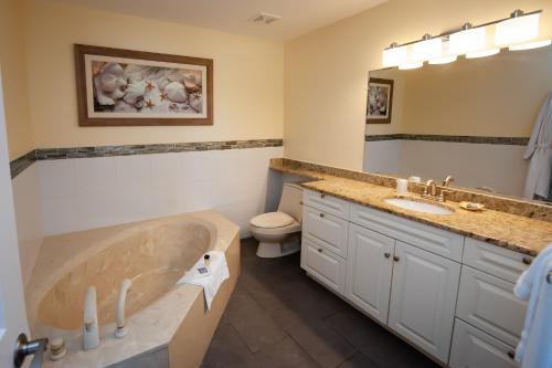 a bathroom with a tub and a toilet and a sink at Cedar Cove Resort & Cottages in Holmes Beach