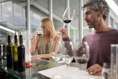 a man and woman standing at a counter with wine glasses at Casa de Uco Vineyards and Wine Resort in Los Árboles