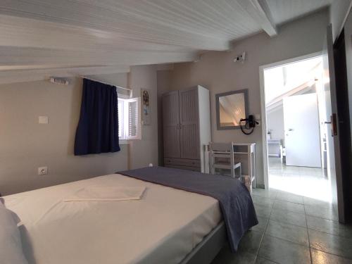een slaapkamer met een groot bed en een blauwe deken bij Venus Rooms in Kateliós