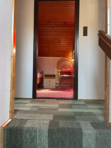 a hallway with a door leading to a room with a chair at Iluska Vendégház in Kiskunmajsa