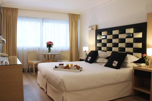 a hotel room with a bed with a tray of food on it at Hôtel Victoria in Cannes