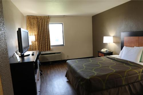 a hotel room with a bed and a flat screen tv at Econo Inn in Columbus