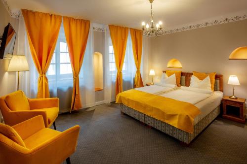 um quarto de hotel com uma cama e uma cadeira em CASA JOSEPH HAYDN em Sighisoara