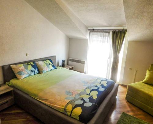 una camera da letto con un letto con un piumone colorato e una finestra di Luxe Apartment a Ohrid