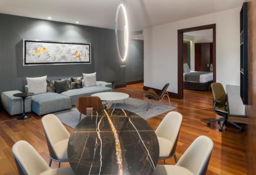 a living room with a couch and a table and chairs at NH Collection Guadalajara Providencia in Guadalajara