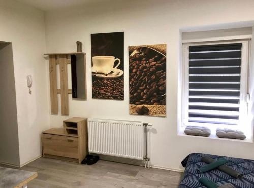a room with three paintings on the wall and a window at Zen Apartmani in Zrenjanin