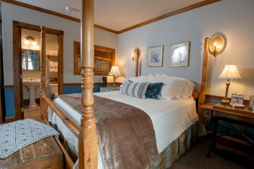 a bedroom with a large bed and a mirror at Inn at Cedar Crossing in Sturgeon Bay