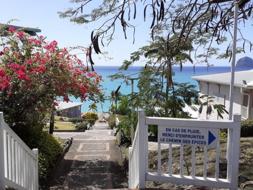 a gate to the beach with a sign on it at Jolie studio vue mer in Le Diamant