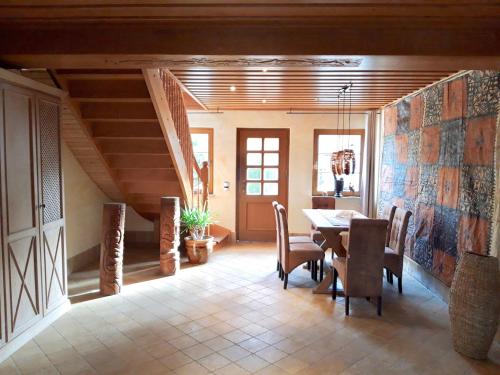 a dining room with a table and chairs and stairs at Ein Bett im Kornfeld - Haus Fernweh - Innenpool in Schönfeld