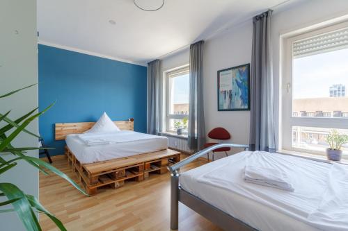two beds in a room with blue walls at #centralstation #130qm Hauptbahnhof #netflix in Karlsruhe