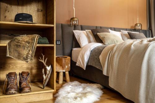 a bedroom with a bed with boots and a rug at Alpin Residenz Dachsteinperle in Ramsau am Dachstein