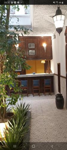 a lobby with a table and chairs and plants at Riad Les Nuits de Marrakech in Marrakech