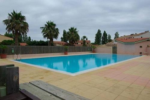 une grande piscine bleue dans une cour dans l'établissement Villa Lauriers roses - Clim Wifi parking - Piscine dans résidence - MARINA ST CYPRIEN, à Saint-Cyprien