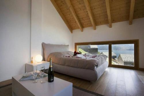 Lavanda house - breathtaking view - في بيلانو: غرفة نوم مع سرير وطاولة مع زجاجة من النبيذ