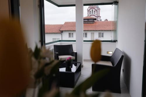 a living room with a view of a large window at Harmony Apartmani Arandjelovac in Arandjelovac