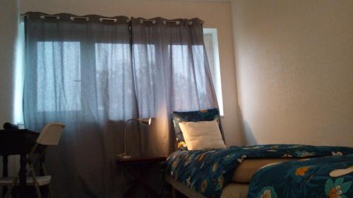 um quarto com uma cama e uma janela com cortinas em chambre lits jumeaux em Chevilly-Larue